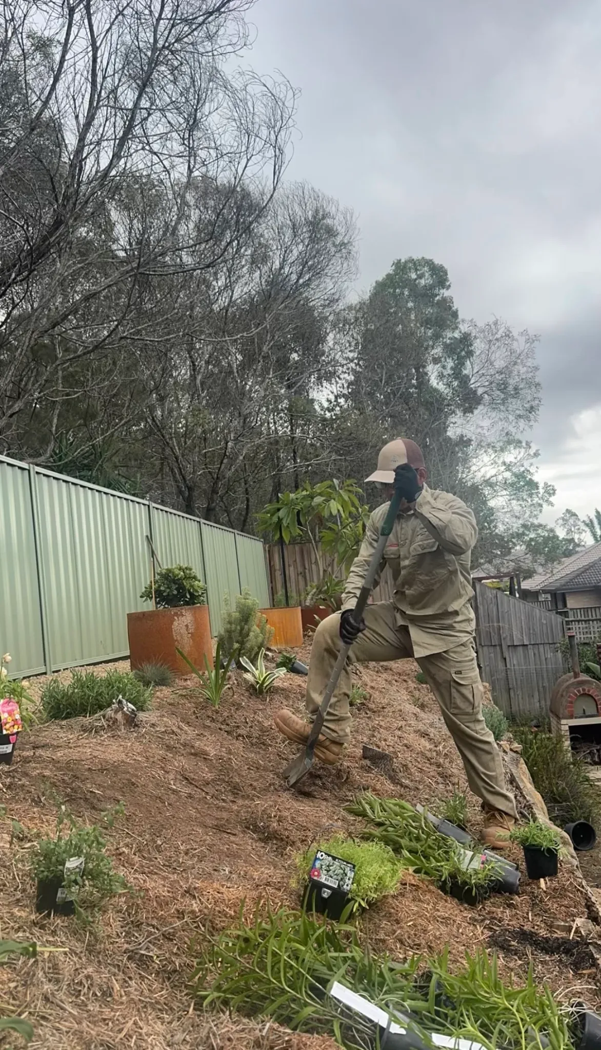 Lou's team member preparing a sloped garden bed for planting