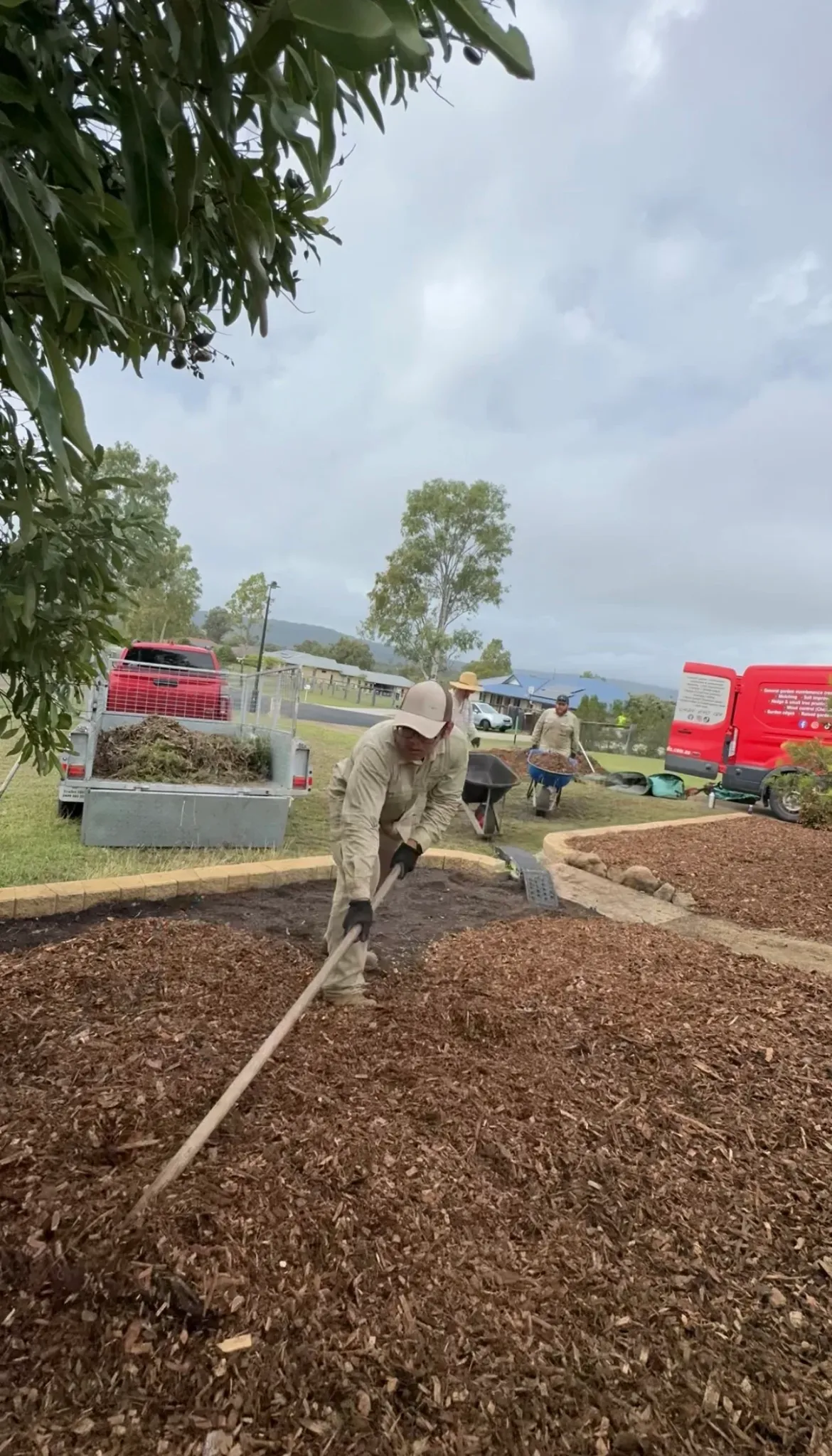 Lou's team spreading mulch across a landscaped area